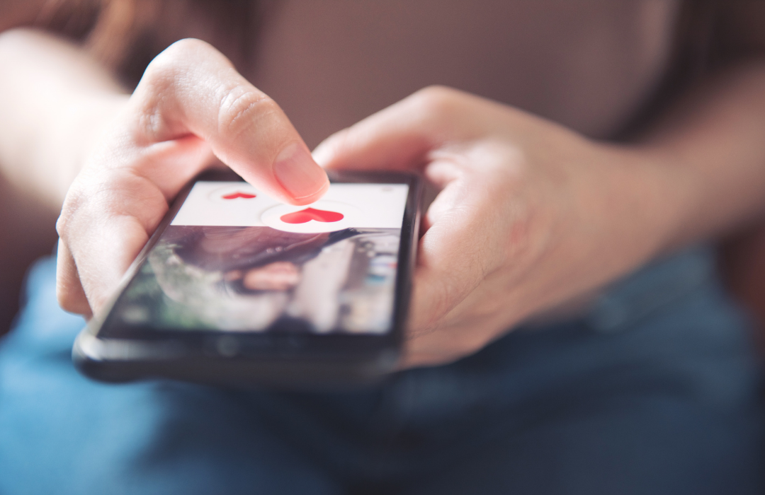 Person holding phone with dating app open