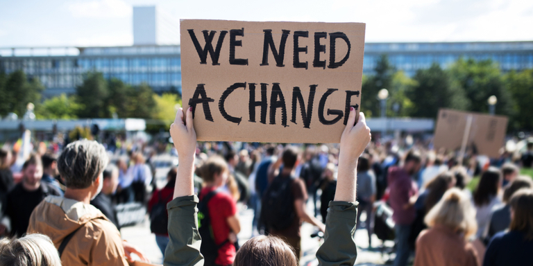 Placard saying 'we need a change' at a protest