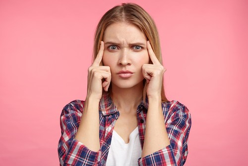 Girl with fingers on her temples looking inquisitive