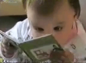 Baby reading a book with wild eyes