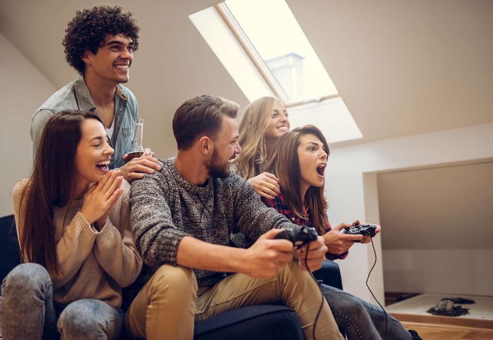 A group of young people playing a video game. They're getting competative